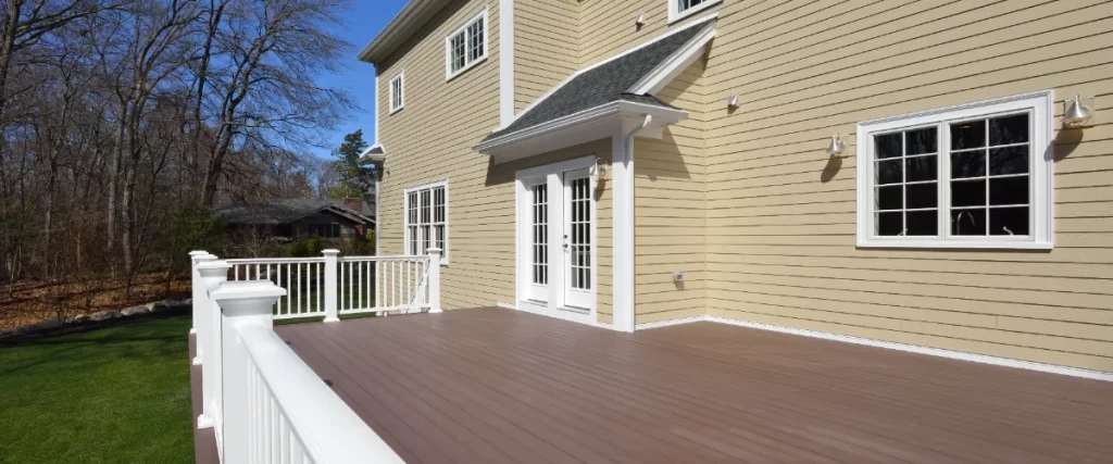 a custom-built composite deck featuring light brown boards and white railings.