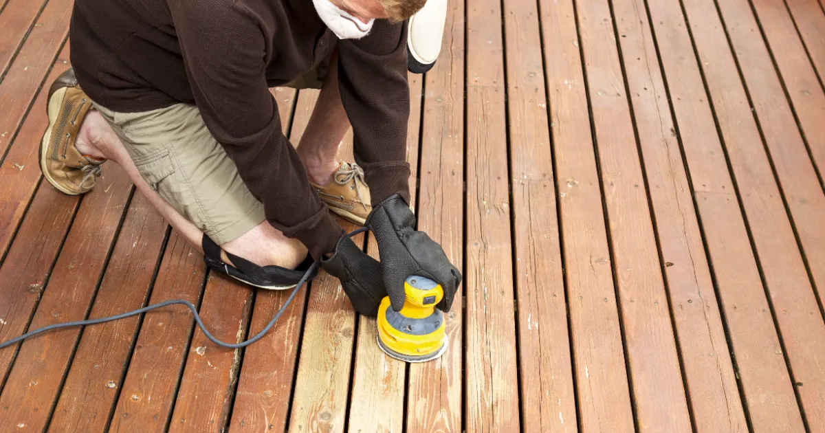 an orbit sander being used to refinish a wooden deck